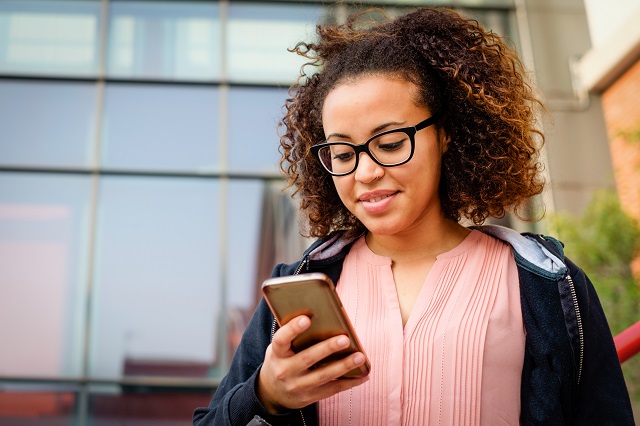 A millennial using her phone to micro-invest.